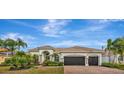 Beautiful home featuring a tile roof, three-car garage and lush tropical landscaping at 2511 Cumberland Cliff Dr, Ruskin, FL 33570