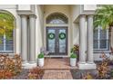 Inviting front entrance with double doors, decorative wreaths, and potted plants at 2511 Cumberland Cliff Dr, Ruskin, FL 33570