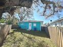The backyard features a lawn, wood fence, and a painted blue exterior that provides a relaxing feel at 4811 Haines N Rd, St Petersburg, FL 33714