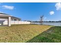 Expansive backyard overlooking a serene lake, complemented by a white fence, offering privacy and tranquility at 11827 Cara Field Ave, Riverview, FL 33579
