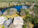 Aerial view showcasing the house's proximity to a serene lake and lush surrounding landscape at 11875 Raintree Dr, Temple Terrace, FL 33617