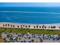 Scenic beach view with clear blue water, palm trees, and parking area at 1200 N Shore Ne Dr # 204, St Petersburg, FL 33701
