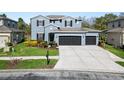 Charming two-story home with a three-car garage, lush lawn and mailbox at 4446 Wildstar Cir, Wesley Chapel, FL 33544