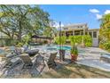 Backyard view with a beautiful pool, outdoor seating, and lush greenery, perfect for relaxation and entertainment at 5010 W Dickens Ave, Tampa, FL 33629