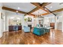 Bright living room featuring hardwood floors, a fireplace, a wet bar, and coffered wood beam ceilings at 5010 W Dickens Ave, Tampa, FL 33629