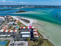 Panoramic aerial shot of beachfront condos with a pristine beach, turquoise water, and city views in the distance at 825 S Gulfview Blvd # 208, Clearwater Beach, FL 33767