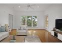 Bright living room featuring hardwood floors, large window, and neutral-toned furniture at 1216 S Missouri Ave # 224, Clearwater, FL 33756