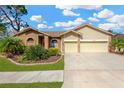 Charming home with a two-car garage, landscaped front yard, and neutral exterior colors at 11209 Bloomington Dr, Tampa, FL 33635
