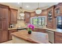 Custom kitchen features wood cabinets, granite countertops, stainless steel appliances, and a butcher block island at 11209 Bloomington Dr, Tampa, FL 33635