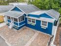 Aerial view of cozy blue single-story home with brick paver driveway and adjacent yard at 1222 Highland N Ct, St Petersburg, FL 33701