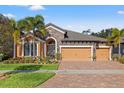 Lovely home with a three-car garage, beautiful landscaping, and a stone facade at 13711 Moonstone Canyon Dr, Riverview, FL 33579
