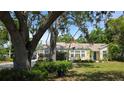Cozy single-story house with a well-maintained lawn and mature trees, creating a serene setting at 1372 Palmetto St, Clearwater, FL 33755
