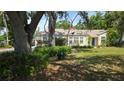 Inviting single-story residence featuring a lovely front lawn and mature trees, perfect for relaxation at 1372 Palmetto St, Clearwater, FL 33755