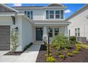 Up close view of a well-manicured home exterior featuring a front porch, stylish landscaping, and an inviting entrance at 9306 Torrent Trail Ct, Sarasota, FL 34241