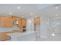 Bright kitchen featuring wood cabinets, stainless steel appliances, tile backsplash, and a large island perfect for entertaining at 9306 Torrent Trail Ct, Sarasota, FL 34241