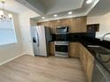 Modern kitchen features stainless steel appliances, granite countertops, wood cabinets, and wood flooring at 6315 Shoreline Dr # 3204, Seminole, FL 33708