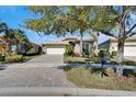 Inviting single-Gathering home with a well-maintained lawn and a brick driveway at 16135 Cape Coral Dr, Wimauma, FL 33598