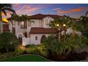 Mediterranean-style home with a red tile roof, arched windows and a beautiful private entrance at 705 Riviera Dunes Way, Palmetto, FL 34221