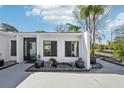 Welcoming entrance with stylish black door, garden, and decorative water feature at 8376 Sycamore Dr, New Port Richey, FL 34654