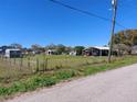 Wide view of the property, fenced in yard, and mature landscaping at 1115 27Th Se St, Ruskin, FL 33570