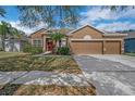Charming single Gathering home featuring a stone facade, three car garage, and beautiful landscaping at 11713 Summer Springs Dr, Riverview, FL 33579
