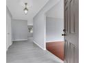 Inviting foyer featuring gray walls, gray wood-look floors, and an ornate chandelier at 1310 Oakdale St, Plant City, FL 33563