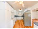 Spacious kitchen featuring white cabinets, stainless steel appliances, and wood floors, perfect for cooking and entertaining at 3302 W Van Buren Dr, Tampa, FL 33611