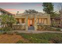 Charming single Gathering home featuring an elegant entryway, manicured landscaping, and a lovely yellow facade at 5807 N Branch Ave, Tampa, FL 33604