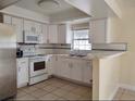 Bright kitchen with white cabinets and countertop seating at 8503 N Willow Ave, Tampa, FL 33604