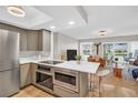 Modern kitchen featuring stainless steel appliances and a breakfast bar overlooking the living area at 1227 Queen Anne Dr # C, Palm Harbor, FL 34684