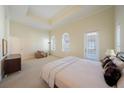 Inviting main bedroom boasting a tray ceiling, ensuite bathroom, and large windows at 3410 Sondrio Cir, Tampa, FL 33611