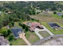 Luxury estate with pool, terracotta roof, and circular driveway in a lush, green neighborhood at 11158 Warm Wind Way, Weeki Wachee, FL 34613