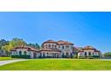 Stunning Mediterranean-style home with a terracotta roof, arched windows, and lush lawn at 11158 Warm Wind Way, Weeki Wachee, FL 34613