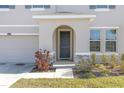 Charming entryway with an arched front door, stone accents, and manicured landscaping at 10944 Delta Huff Ct, San Antonio, FL 33576