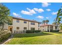 Beautiful multi-story home featuring a red tile roof, lush landscaping, and a well-manicured lawn at 1003 Hammock Pine Blvd # 1003, Clearwater, FL 33761