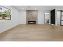 Spacious living room with a sleek fireplace, wood-look flooring, and a modern barn door leading to the bathroom at 1520 Arnold Ave, Brooksville, FL 34601