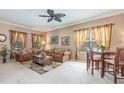 Comfortable living room with neutral tones, ceiling fan, and matching furniture set around a wooden coffee table at 6214 45Th E Ln, Bradenton, FL 34203