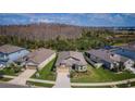 Aerial view of a well-maintained home with manicured lawn and mature trees at 7580 Pool Compass Loop, Wesley Chapel, FL 33545