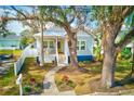 Inviting home featuring a lovely landscaped front yard, stone walkway, and a charming front porch with an American flag at 112 17Th E St, Bradenton, FL 34208