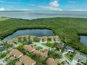 Aerial view of a community with a lake, lush greenery, and stunning water views at 14766 Feather Cove Ln, Clearwater, FL 33762