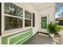 Charming home entrance featuring a green door and classic architectural accents at 200 Glennes Ln # 103, Dunedin, FL 34698