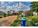 Charming home featuring a brick driveway, mature landscaping, and inviting front porch area at 2359 Emerald Lake Dr, Sun City Center, FL 33573