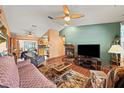 Inviting living room with a ceiling fan, hardwood floors, a stone fireplace and neutral colors at 2940 Bay View Dr, Safety Harbor, FL 34695