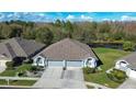 Stunning aerial view of a home with a well-manicured lawn, pond, and mature trees in the backyard at 31841 Larkenheath Dr, Wesley Chapel, FL 33543