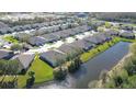 Aerial view of a residential community featuring well-maintained homes, streets, and a serene pond at 31841 Larkenheath Dr, Wesley Chapel, FL 33543