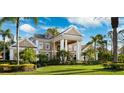 Beautifully landscaped home featuring mature palm trees, manicured lawn, and impressive architectural details at 4110 Highland Park Cir, Lutz, FL 33558