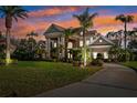 Elegant home featuring stately columns and lush landscaping at dusk at 4110 Highland Park Cir, Lutz, FL 33558