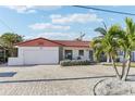 Charming single-story home with a red tile roof, an attached garage, and a neatly paved driveway at 619 59Th Ave, St Pete Beach, FL 33706