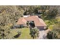 Aerial shot of a home surrounded by lush trees, featuring a swimming pool and a spacious backyard at 6524 Coronet Dr, New Port Richey, FL 34655