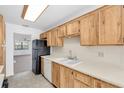 Eat-in kitchen features light wood cabinets, a white tile backsplash, and modern appliances at 8199 Terrace Garden N Dr # 212, St Petersburg, FL 33709